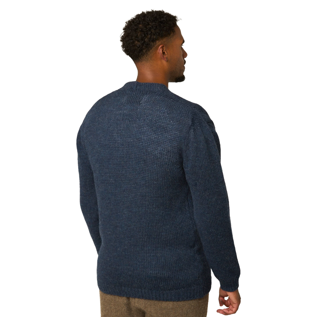 A man wearing a textured navy blue knit sweater, shown from a rear three-quarter view against a plain white background.