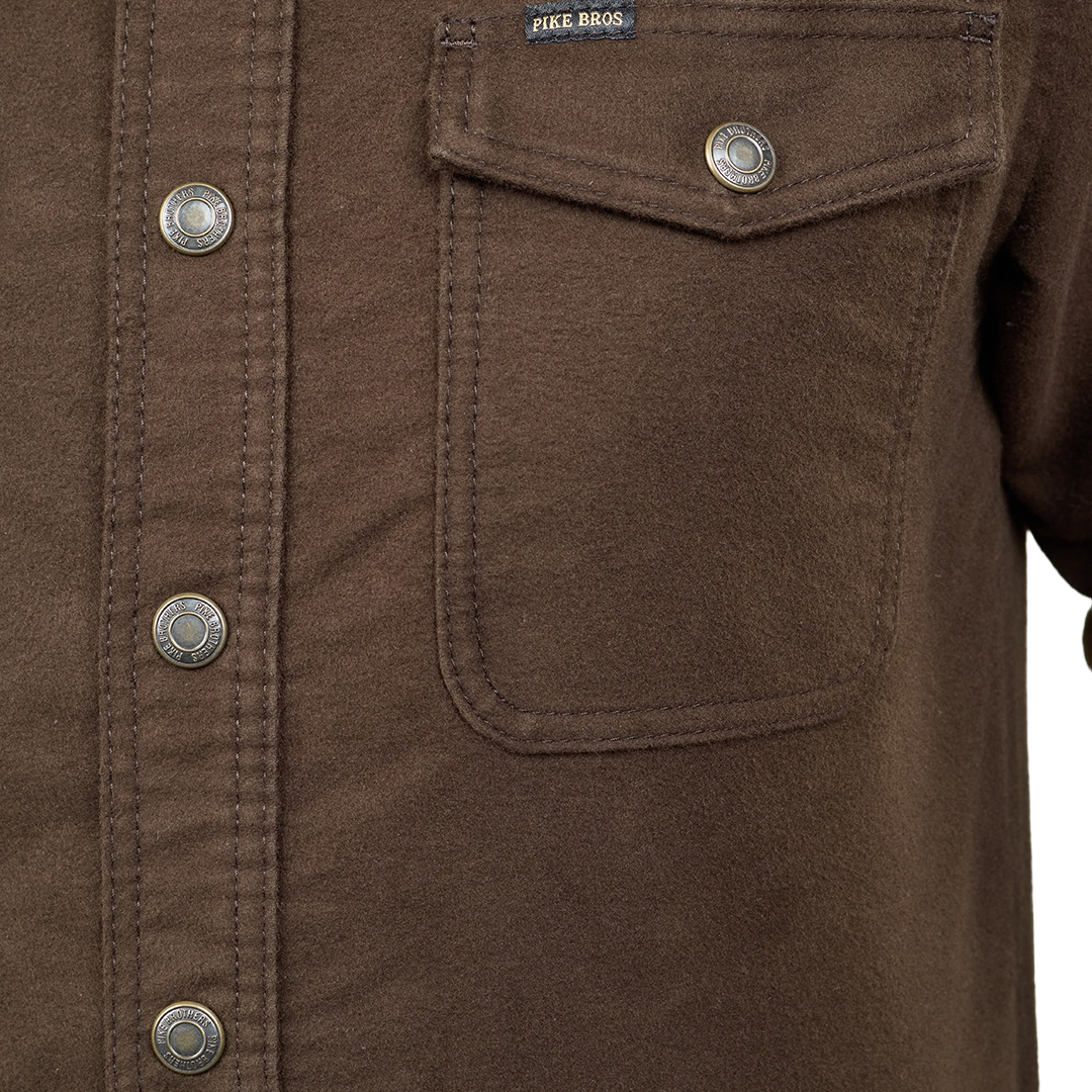 Close-up of a brown button-up shirt with a chest pocket, metal snap buttons, and a visible FIKR.BROS. label.