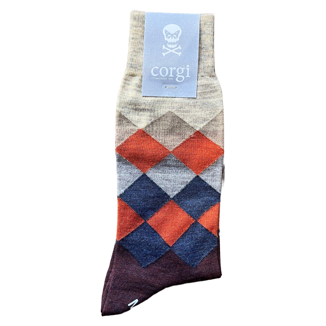 A single argyle pattern crew sock with a light blue Corgi brand tag, featuring diamond shapes in rust orange, navy blue, and gray on a heathered beige base, with a dark purple gradient at the toe.