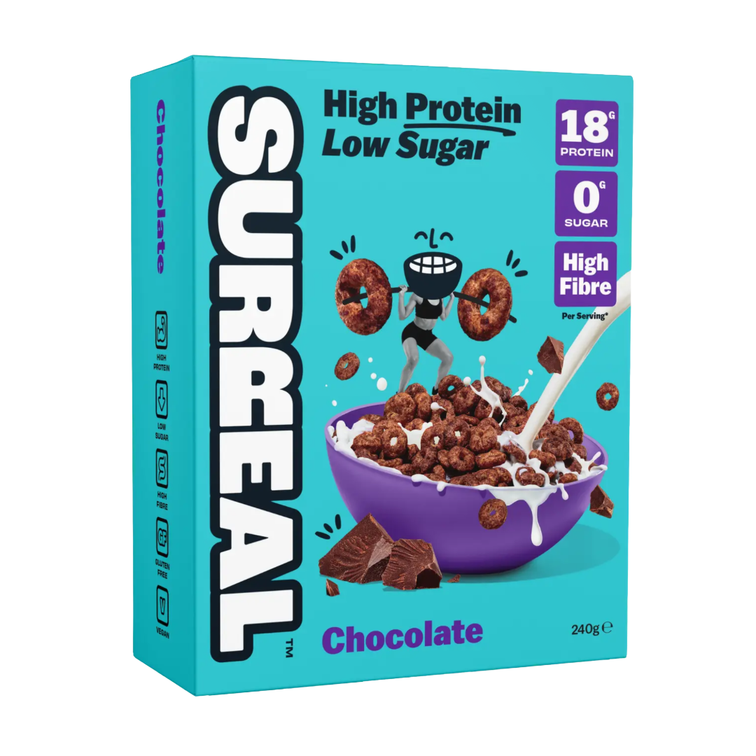 A box of SURREAL Chocolate high protein cereal, featuring a bright turquoise background with bold white and black SURREAL branding, a bowl of cereal, chocolate pieces, and nutritional callouts on the right.