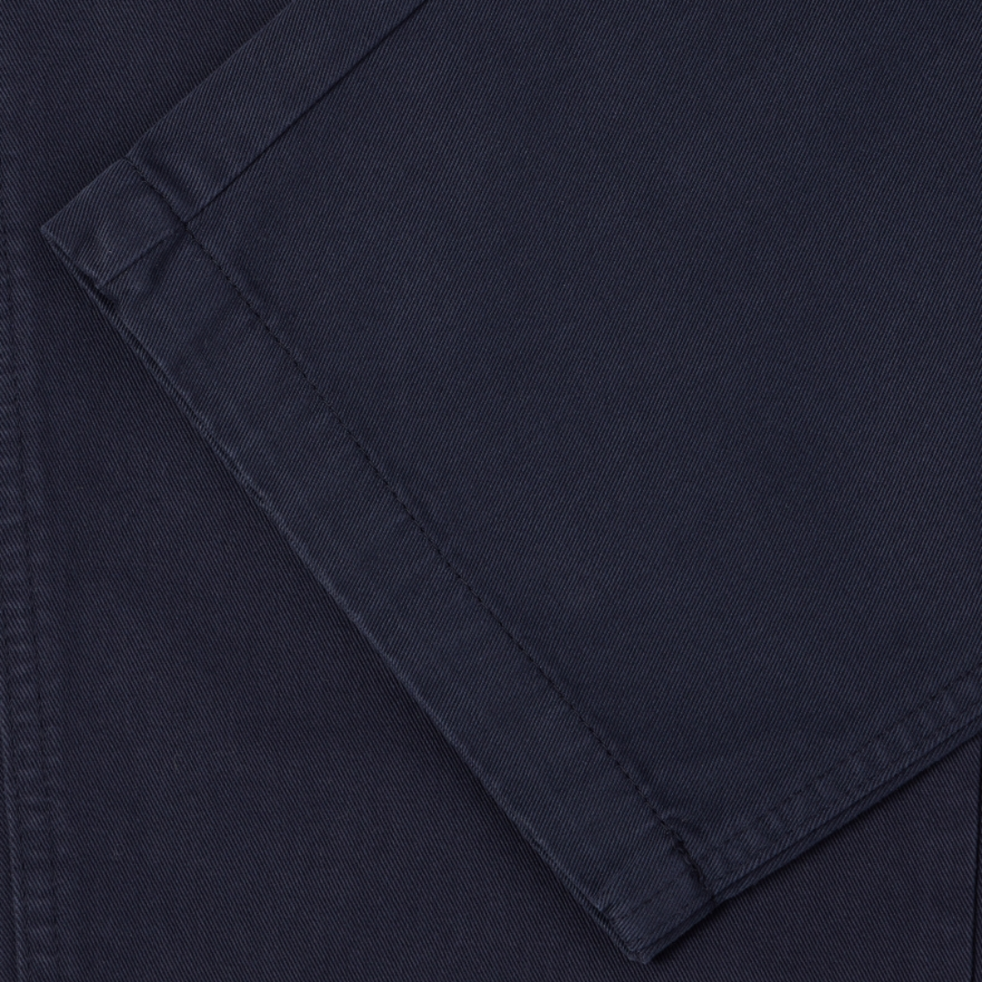 Close-up of dark navy blue fabric with a folded corner showing the texture and stitching.