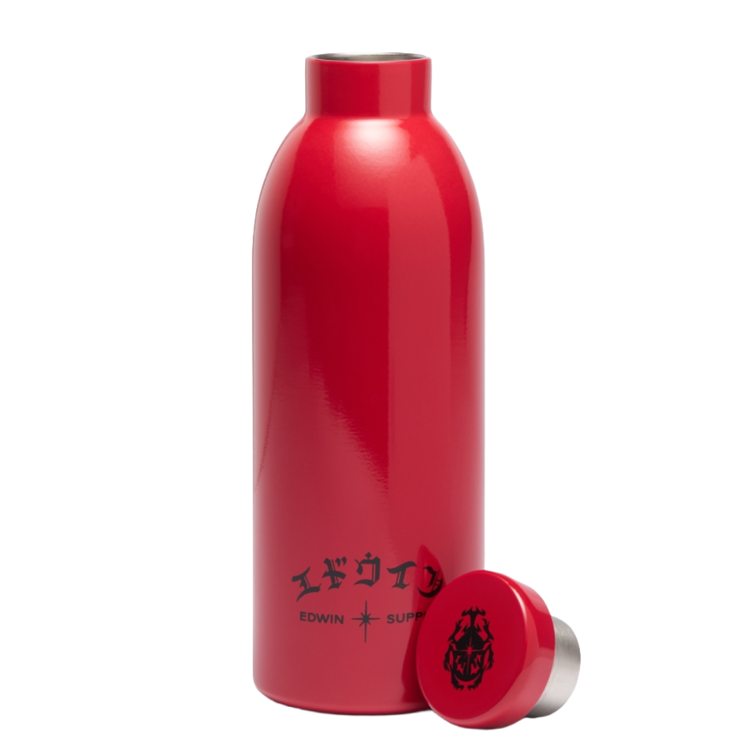 A red insulated water bottle with a matching red lid placed in front, shown on a clean white background. The bottle has black printed text near the bottom and a black crest-style logo on the lid.