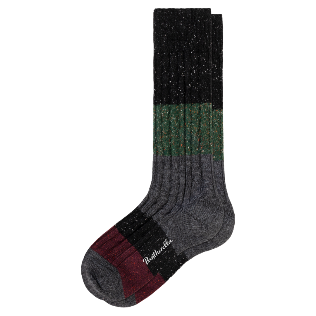A pair of Roshulilla brand crew socks featuring a color-blocked design with a black upper section, a green middle section with subtle multicolor flecks, a dark gray lower section, and a burgundy toe cap.