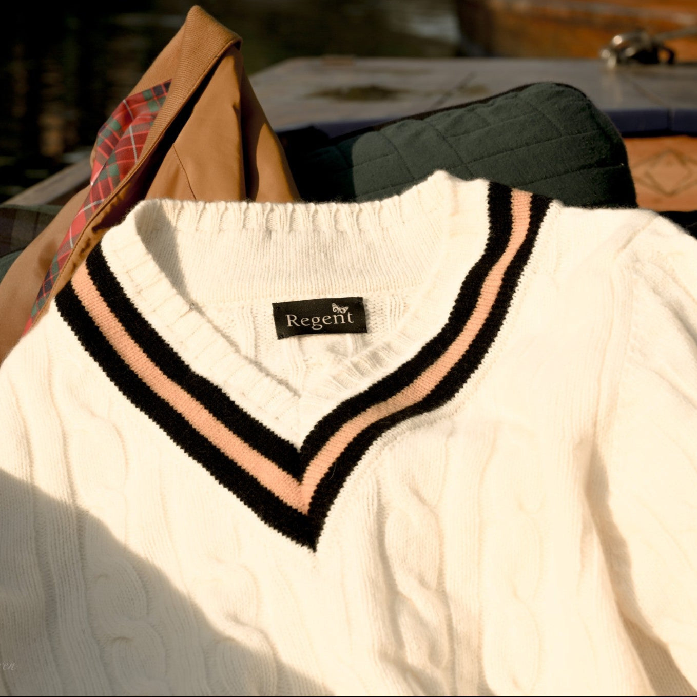 White sweater with black and pink trim on a hanger