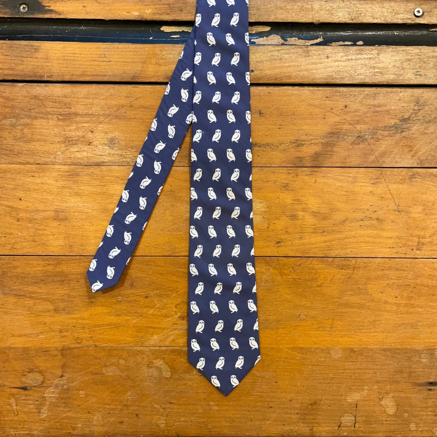 blue cotton tie with owl pattern on boards
