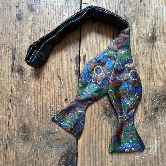 Green silk bow tie with blue paisley pattern