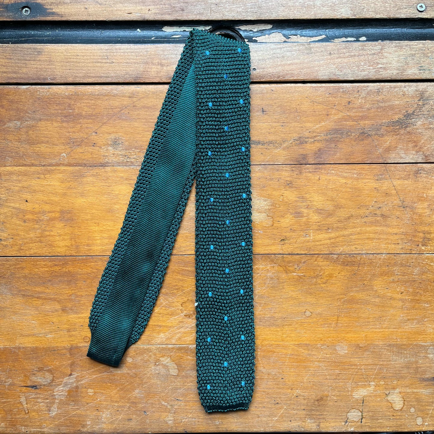 Regent knitted tie in bottle green with sky blue spots