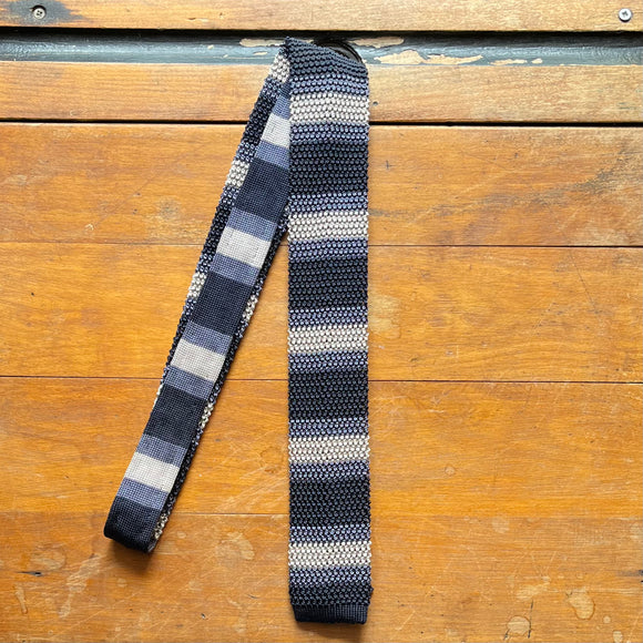 Regent knitted silk tie in alternating stripes of slate grey and champagne, and navy blue