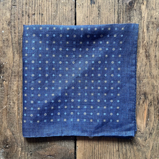 Blue linen pocket square with a white and yellow repeated pattern