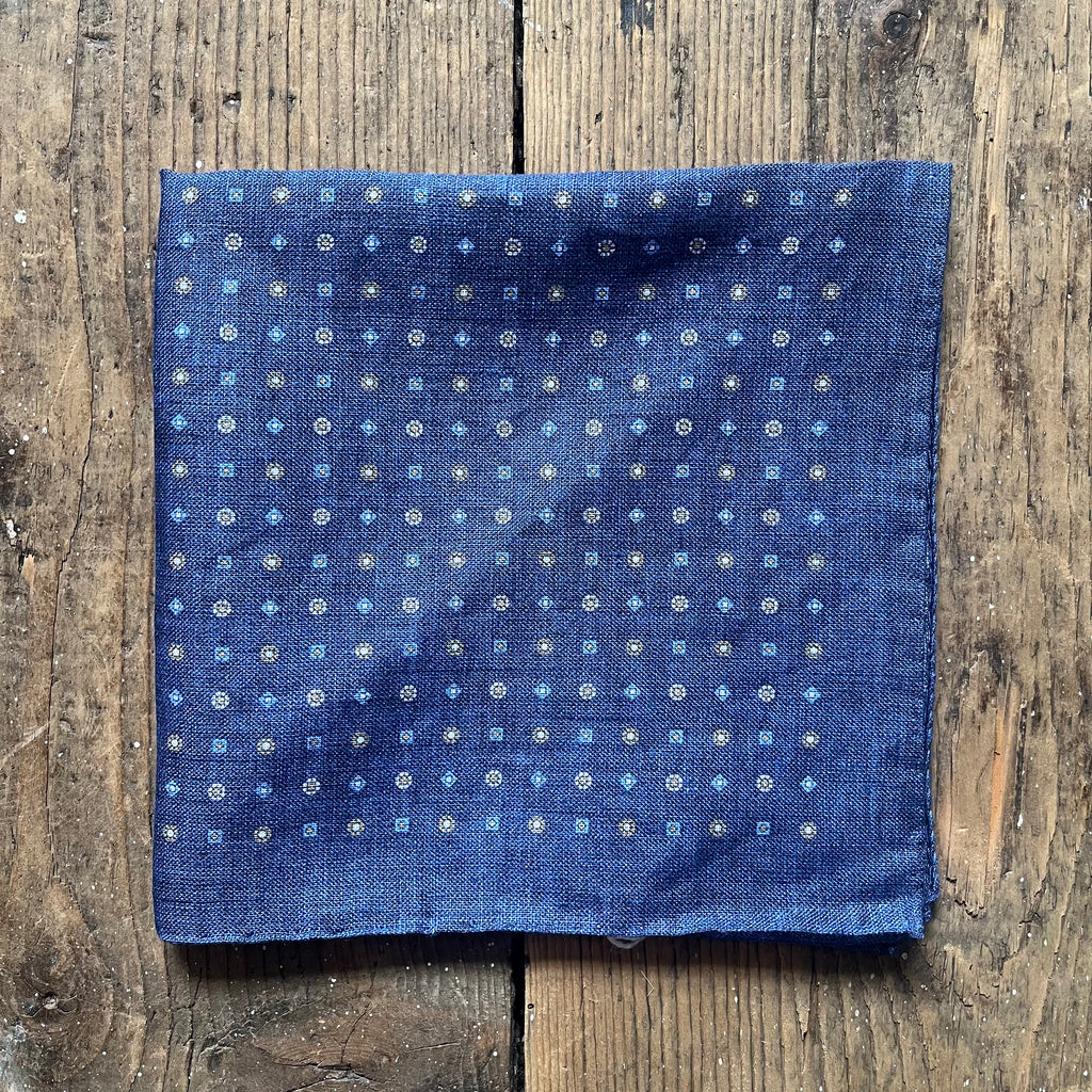 Blue linen pocket square with a white and yellow repeated pattern