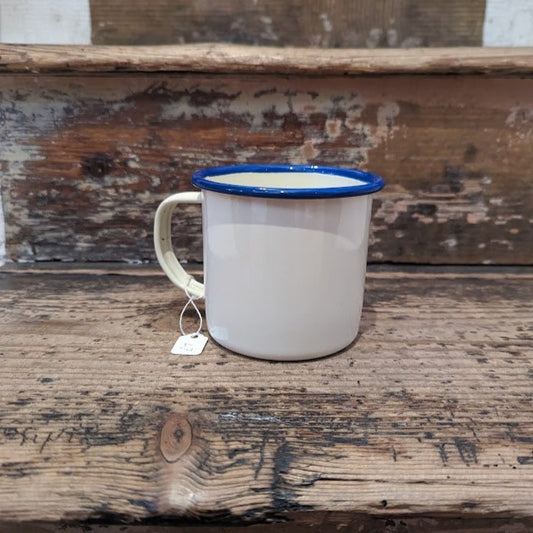 Cream enamel mug, curved handle and blue rim.