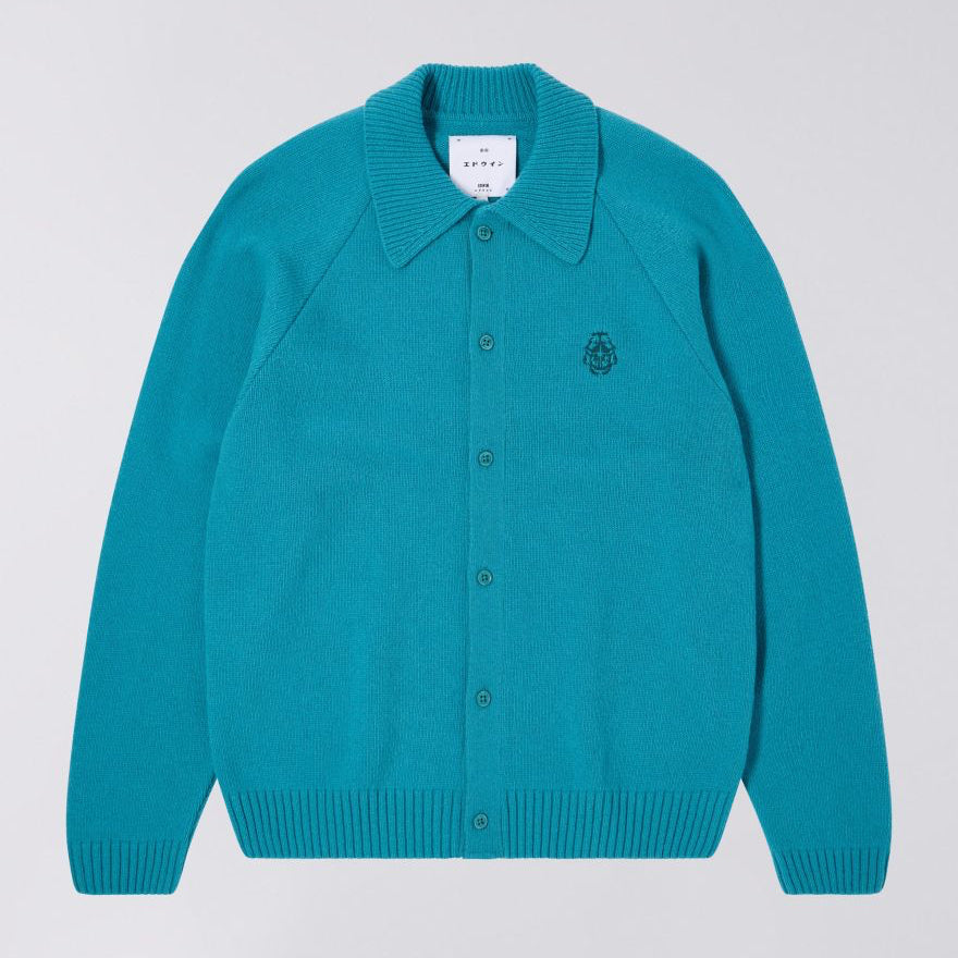 Teal cardigan with a brand label on a light gray background