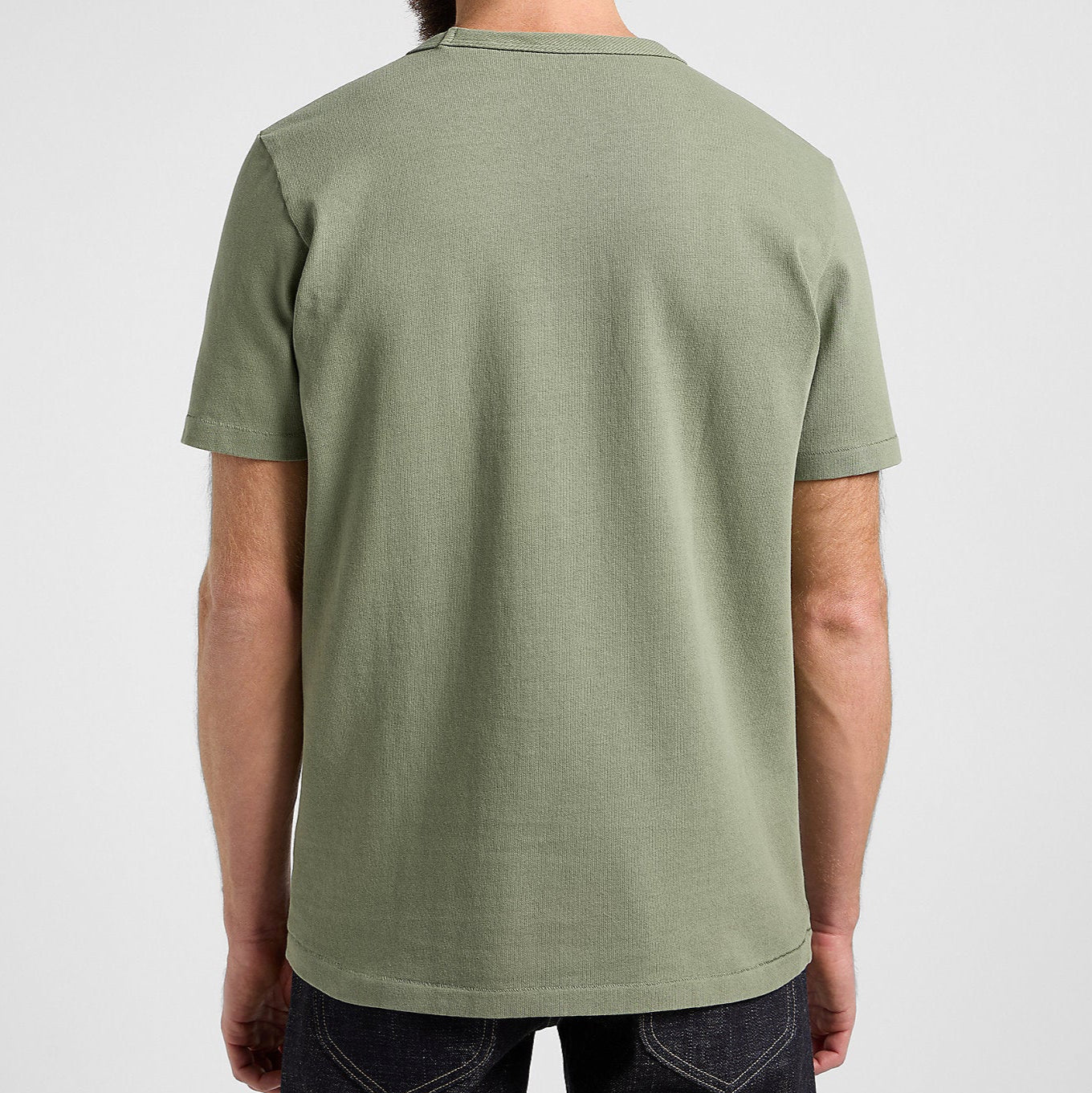 Person wearing a green t-shirt on a plain background