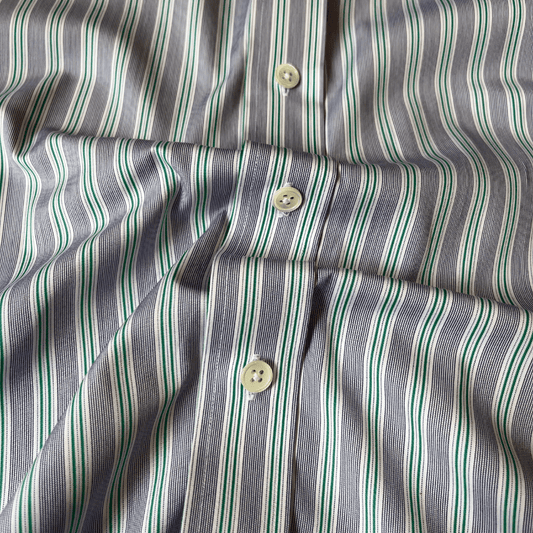 Close-up of a striped shirt fabric with vertical stripes in green, white, and gray, featuring mother of pearl buttons.2