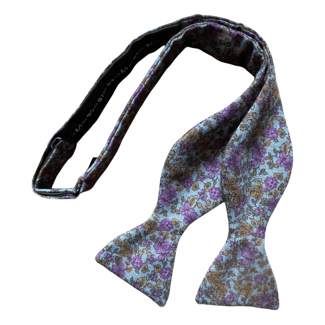 Regent Tailoring wool bow tie in blue with purple floral pattern and bronze leaf details, adjustable strap.