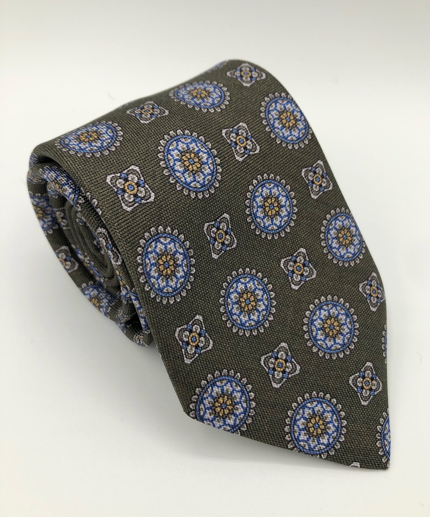 A luxury wool and silk tie designed by and handmade exclusively for Regent. A smart, Italianate olive is picked out by church-like stain-glass geometric shapes.