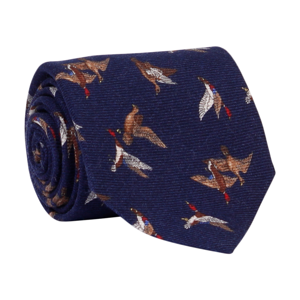 A luxury wool and silk tie designed by and handmade exclusively for Regent. A crisp peaceful wintery night navy is traversed by a flock of wild ducks.