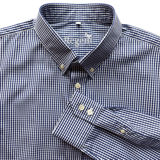 Close-up of a Regoff men's dress shirt in a navy and white micro-check gingham pattern, featuring a button-down collar and a folded cuff with three buttons.
