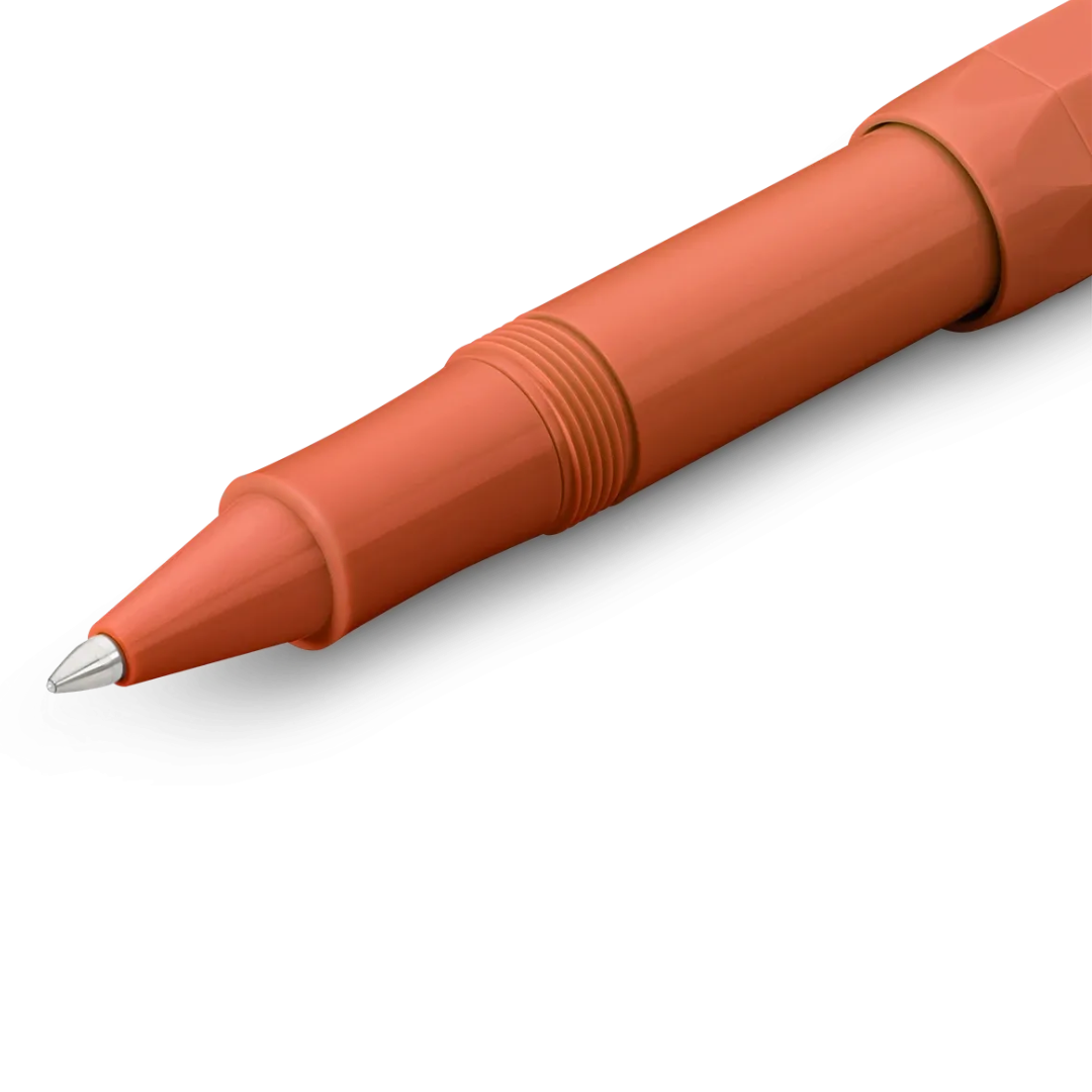 A close-up of a terracotta orange ballpoint pen showing the tip, clicker, and textured barrel against a clean white background.