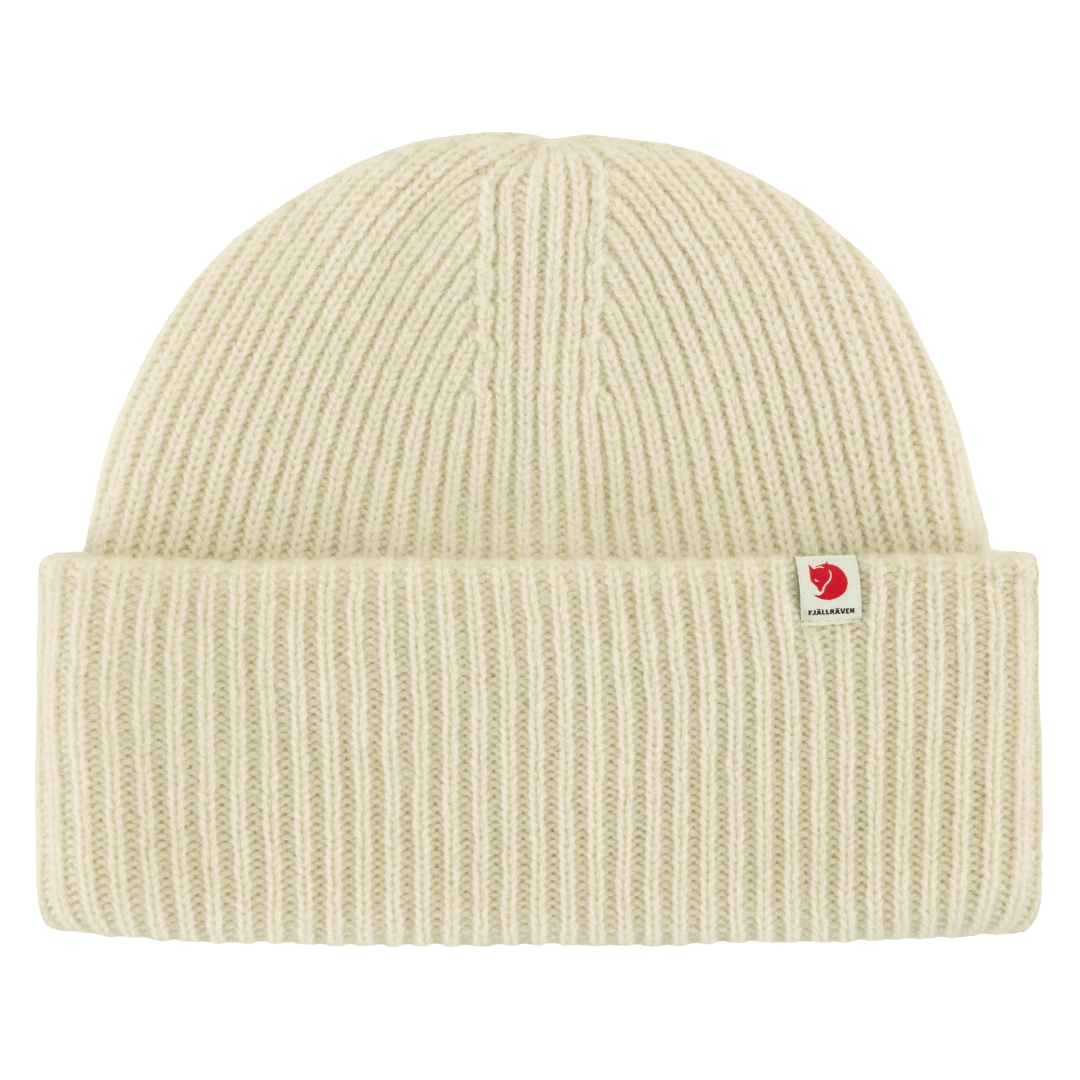 A cream-colored ribbed knit beanie hat with a small red and white Fjällevär logo patch on the front cuff, shown against a solid white background.