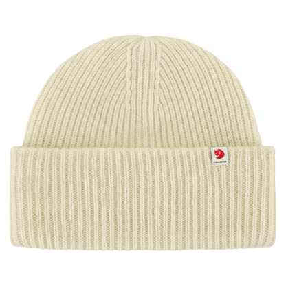 A cream-colored ribbed knit beanie hat with a small red and white Fjällevär logo patch on the front cuff, shown against a solid white background.