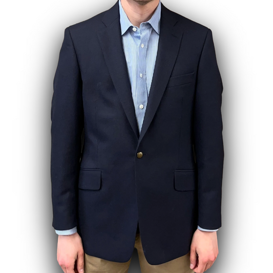 Navy blazer over a light blue shirt with a white background