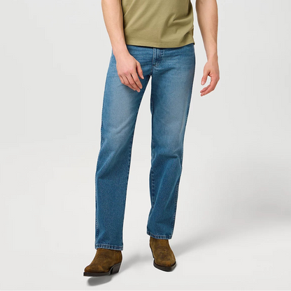 Man wearing a green t-shirt and blue jeans on a white background