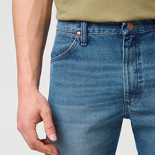 Close-up of blue jeans worn by a person on a plain background