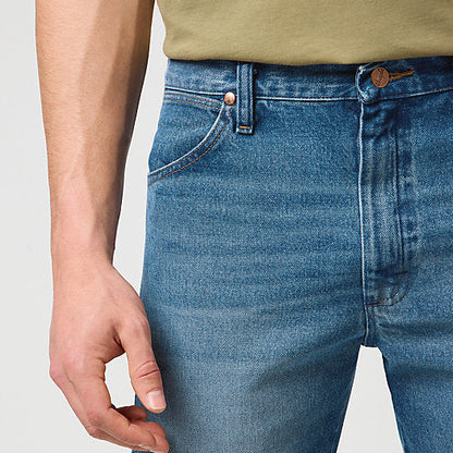 Close-up of blue jeans worn by a person on a plain background