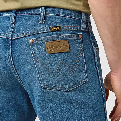 Close-up of blue jeans with a brand patch on a white background