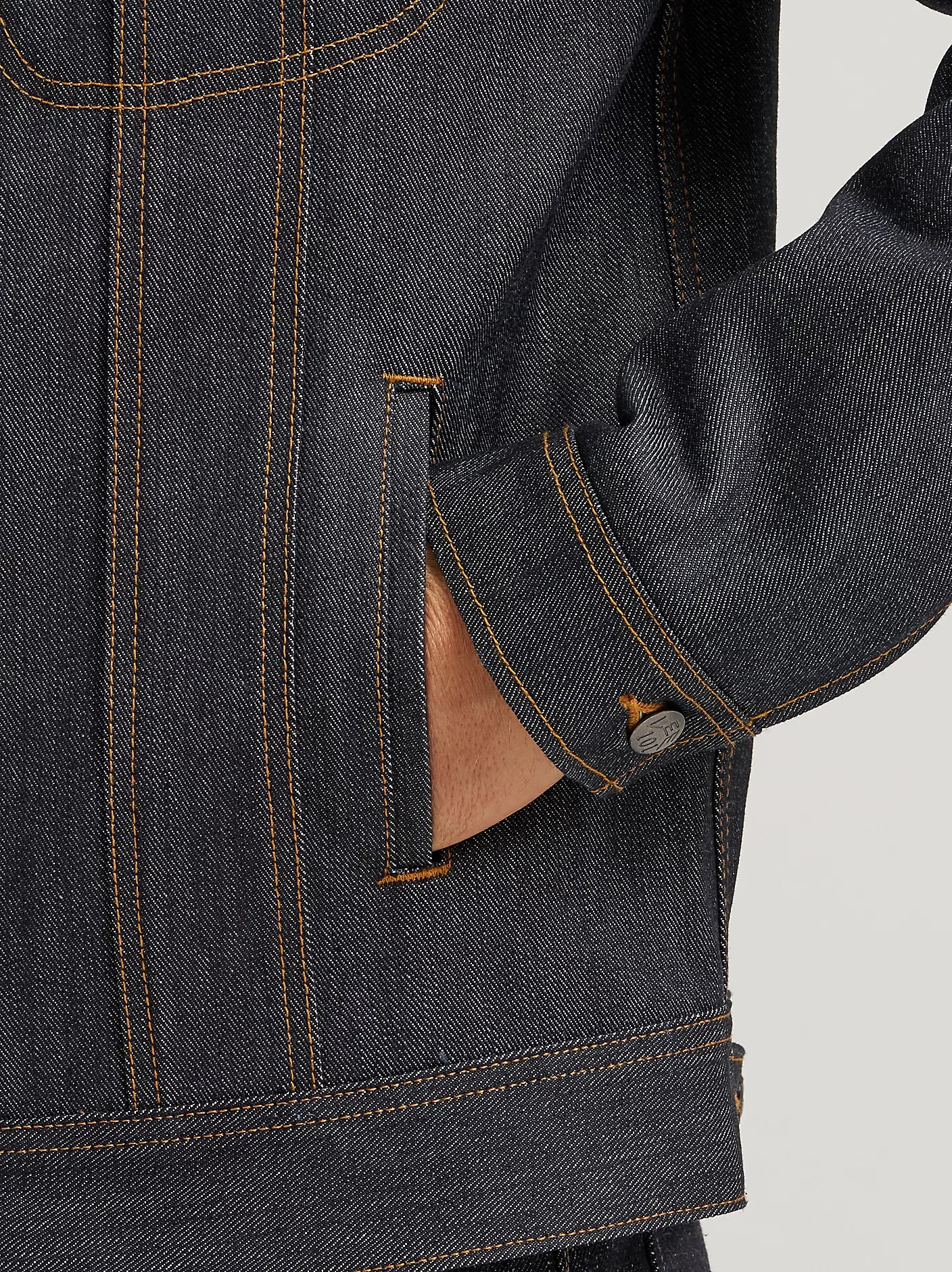 Close-up of a dark denim jacket with brown buttons and collar.