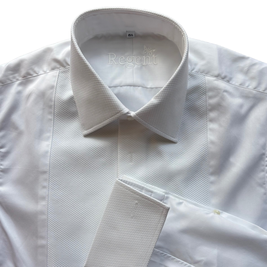 A close-up of a white long-sleeve dress shirt with a textured, fine-gauge knit collar and a matching white necktie, laid flat against a white background. The brand name 'Regent' is printed inside the collar.