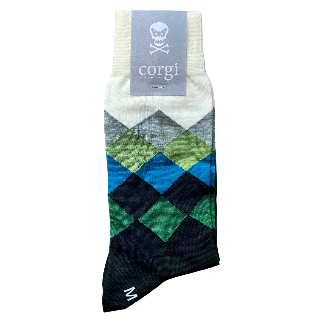 A single argyle patterned sock with a gray paper tag at the cuff. The sock features a diamond pattern in green, blue, and black, with a cream cuff and heel.