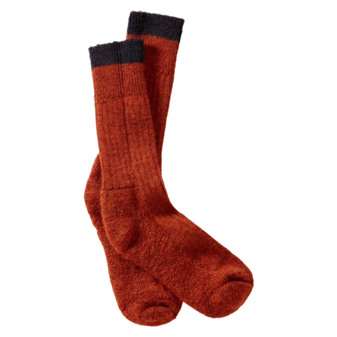 A pair of textured knit crew socks in a rust-orange color with a dark charcoal gray ribbed cuff, displayed against a solid white background.