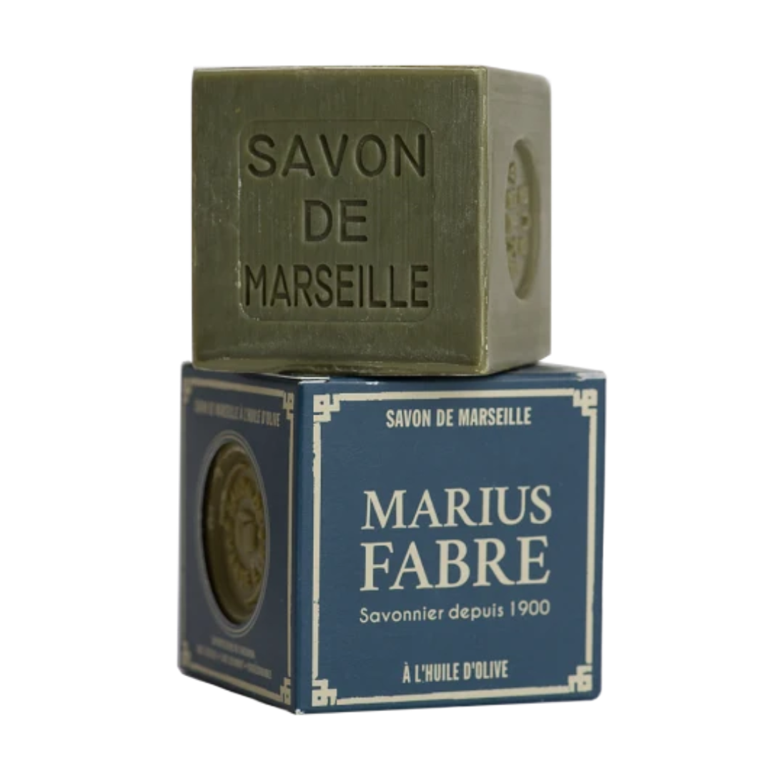 A square bar of olive-green Savon de Marseille soap stacked on top of its dark blue retail box, which features the brand name 'Marius Fabre' in white text.