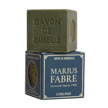 A square bar of olive-green Savon de Marseille soap stacked on top of its dark blue retail box, which features the brand name 'Marius Fabre' in white text.