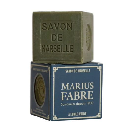 A square bar of olive-green Savon de Marseille soap stacked on top of its dark blue retail box, which features the brand name 'Marius Fabre' in white text.