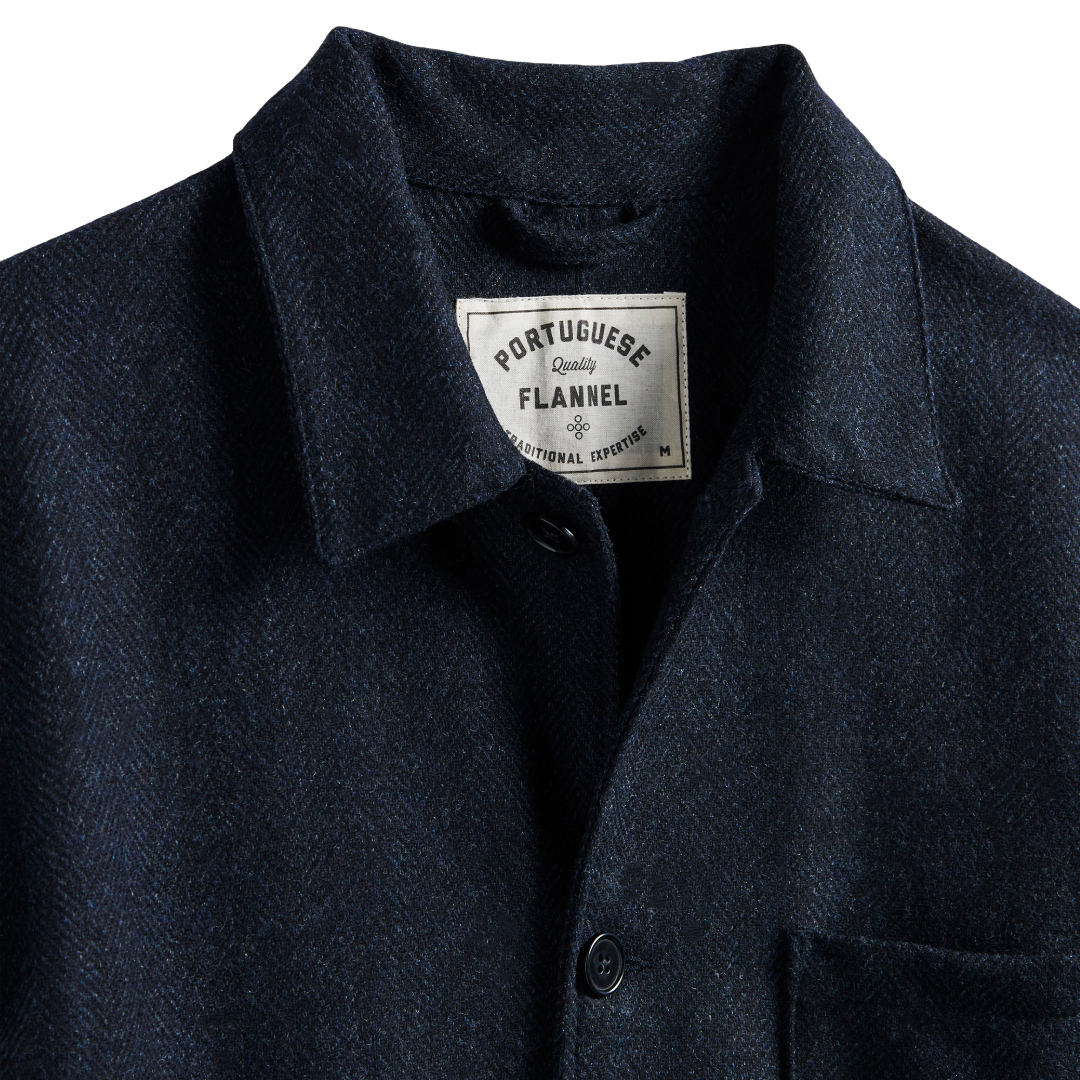 Close-up of a dark navy Portuguese flannel button-up shirt collar with a visible brand label.