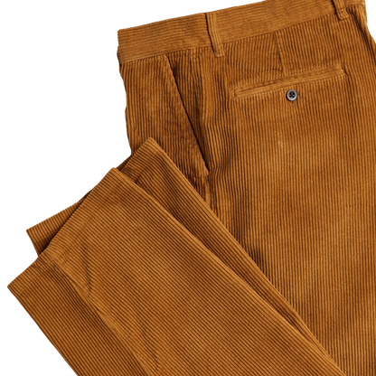 Close-up of a pair of brown corduroy trousers showing the front waistband, belt loops, and the back of a pocket with a metal button, on a plain white background.