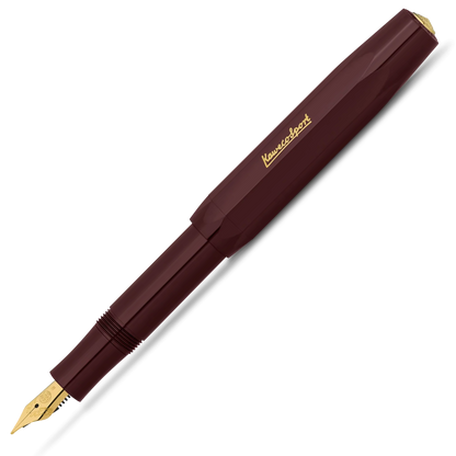 A Kuvings fountain pen in a deep burgundy barrel with gold accents, including the brand name 'Kuvings' on the cap and the nib. The pen is shown diagonally on a clean white background.