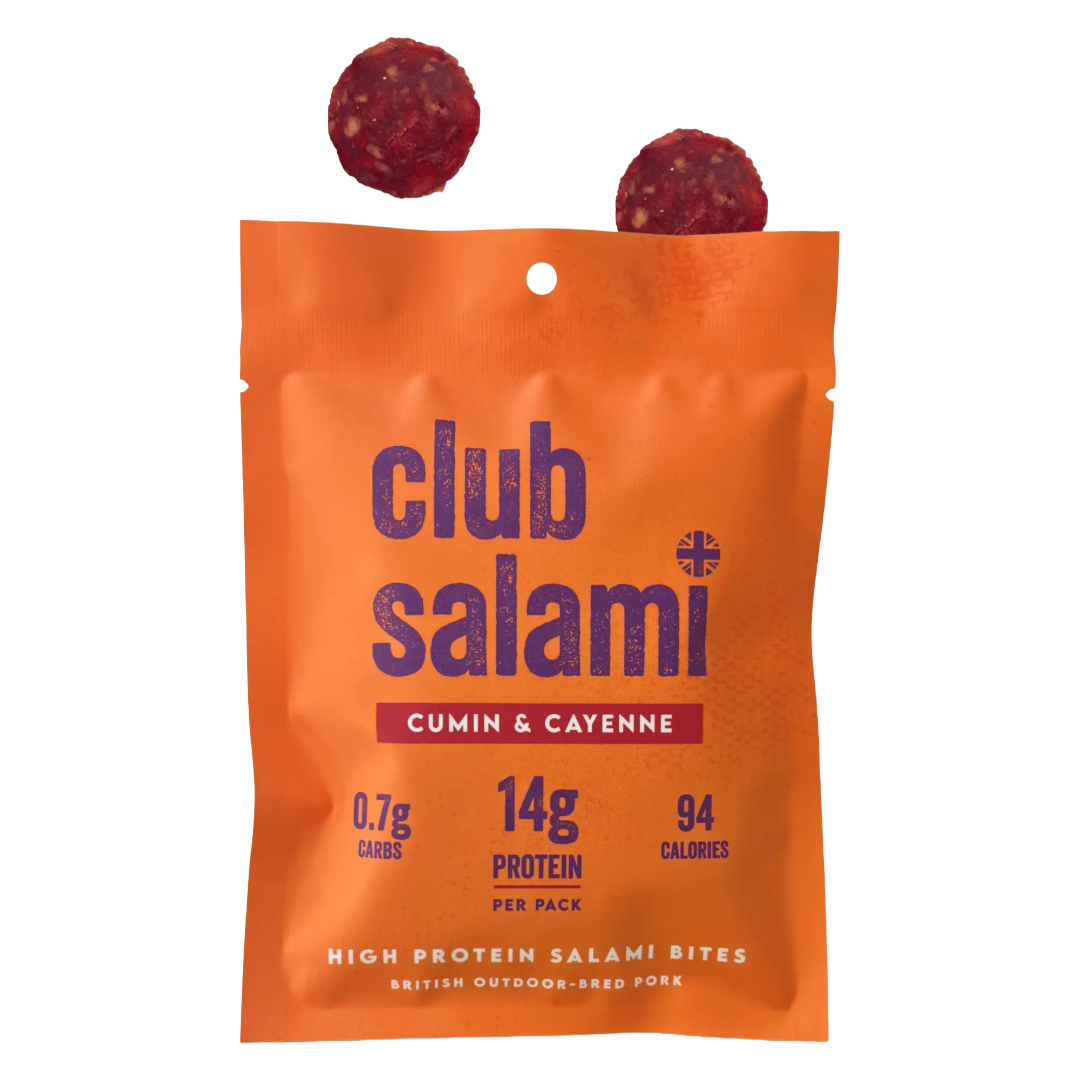 An orange stand-up pouch of Club Salami Cumin & Cayenne high protein salami bites, with two round salami slices floating above the bag on a white background.
