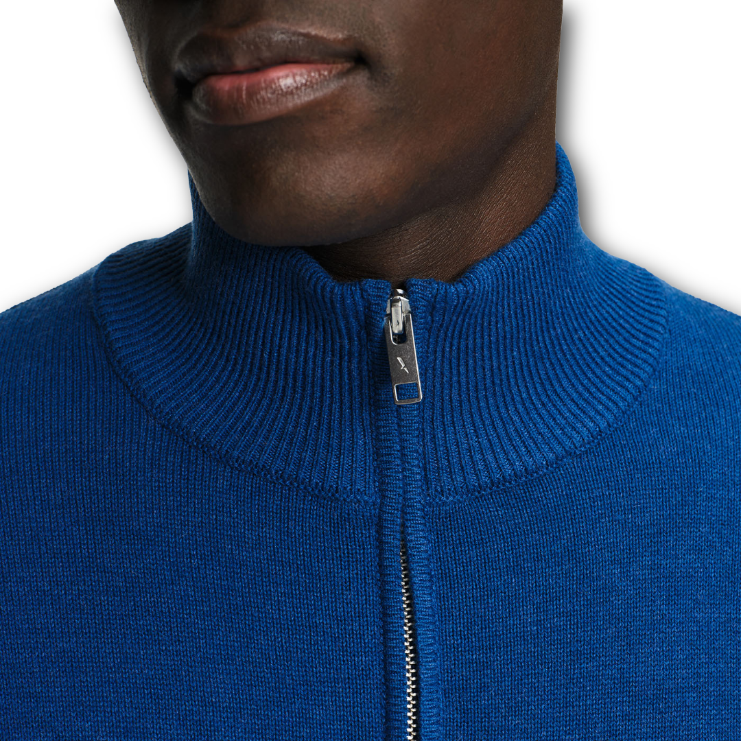 Close-up of a person wearing a blue Aigle sweater with a zipper on a white background sold at Regent in Salisbury