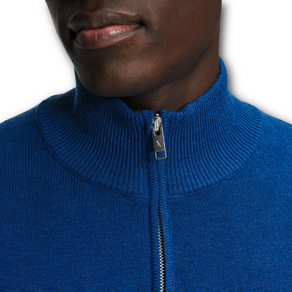 Close-up of a person wearing a blue Aigle sweater with a zipper on a white background sold at Regent in Salisbury