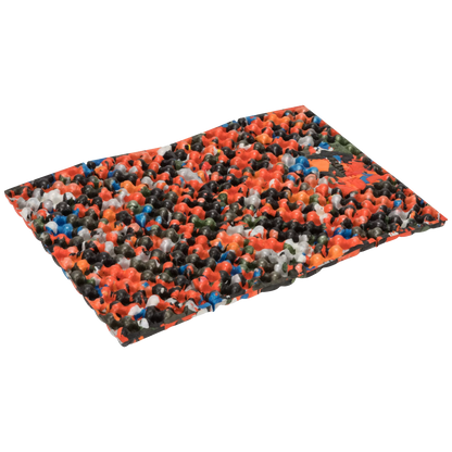 A rectangular mat covered in a dense multicolor pattern of small plastic-like pieces, shown at an angle on a plain white background.