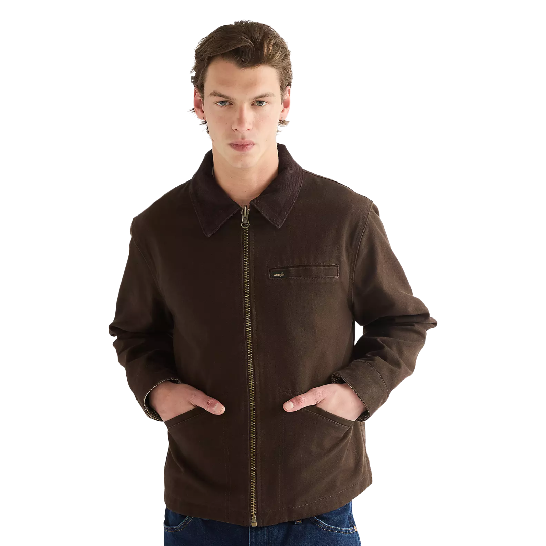 A man wearing a dark brown zip-up jacket with a corduroy collar and front pockets, paired with blue jeans, against a solid white background.