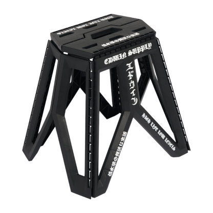 A black foldable step stool with white Japanese text printed on its side, shown on a clean white background.