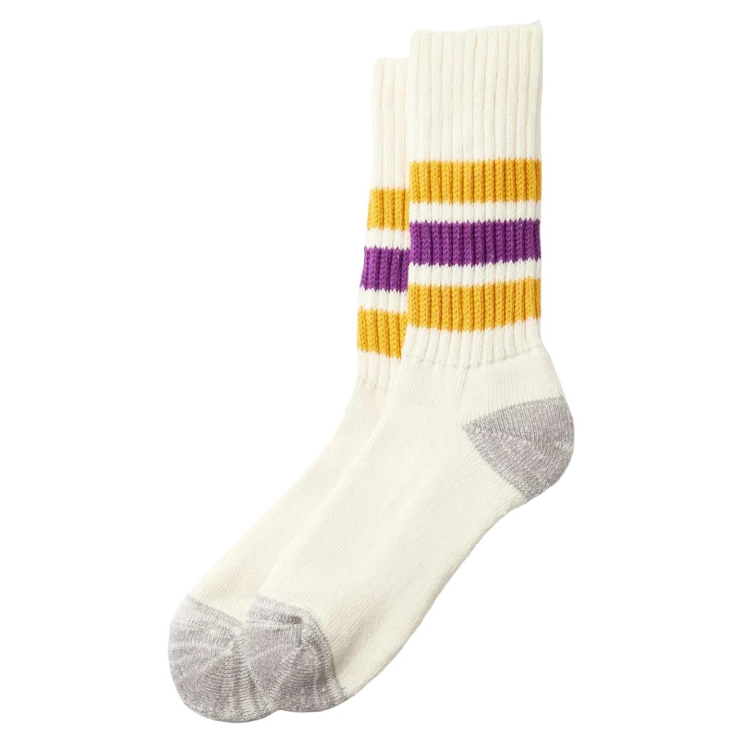 A pair of cream-colored crew socks with yellow and purple stripes near the cuff, gray heels and toes, and ribbed cuffs, shown against a plain white background.