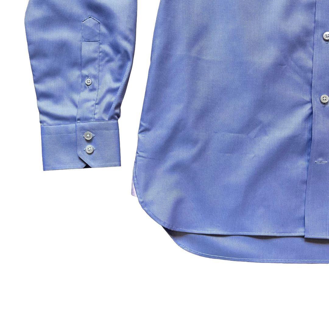 Close-up of a light blue long-sleeve dress shirt showing the front button placket and the folded cuff with button details