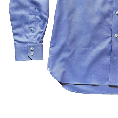 Close-up of a light blue long-sleeve dress shirt showing the front button placket and the folded cuff with button details