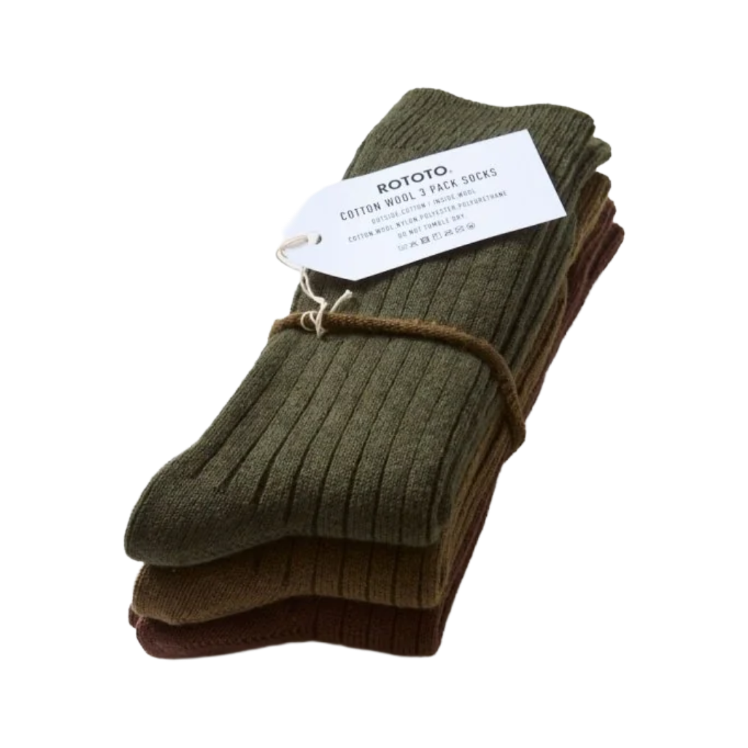 A stack of three ribbed cotton wool socks tied with a string, featuring a white paper tag with the brand name 'ROTOTO'. The top sock is olive green, and the bottom socks are dark brown, set against a plain white background.